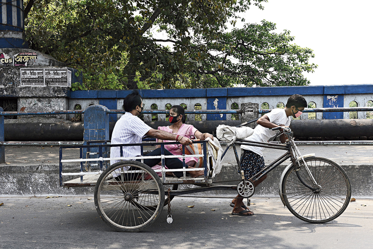 A man, accompanied by a woman, on his way to a local doctor in the Bagmari area