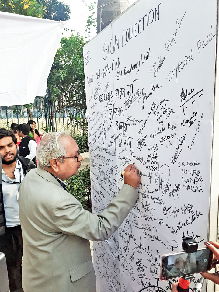 Former Bengal home secretary Prasad Ranjan Roy signs the wall
