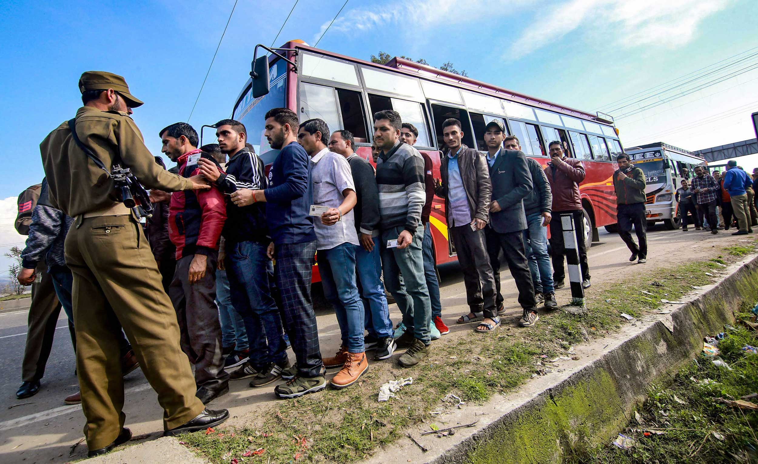 Police frisk passengers on the Jammu-Srinagar highway following a grenade blast at a bus stand in Jammu on Thursday. 