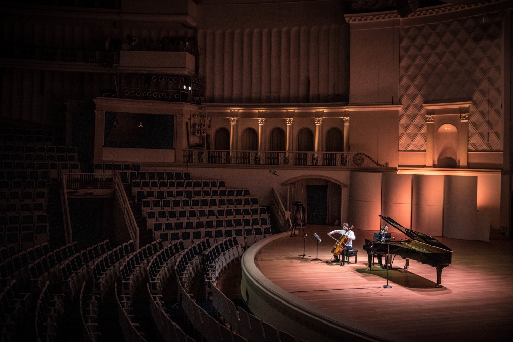 Pianist Lukas Geniusas and cello Alexandre Bouzlov performs on a stage at Tchaikovsky Concert Hall while preparing for an online broadcast, during a rehearsal in Moscow, Russia, Saturday March 21, 2020.