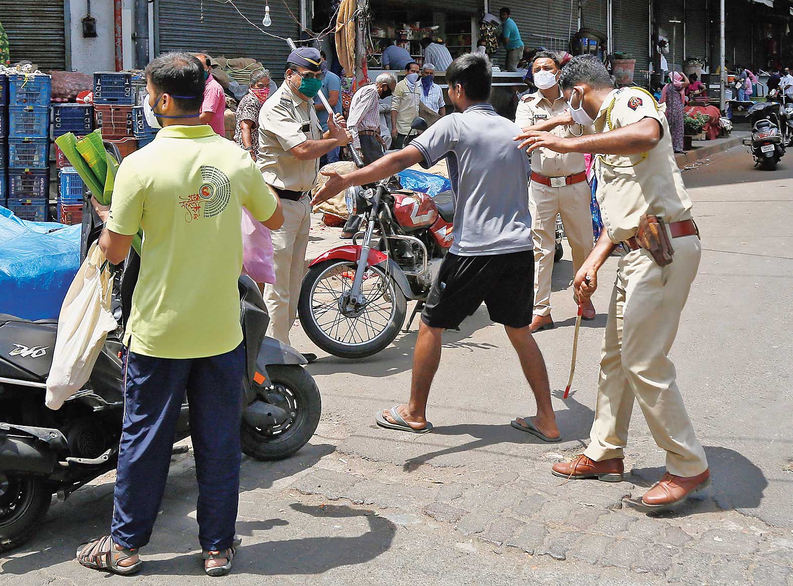 Police wield the stick to enforce the lockdown and send people indoors in Mumbai on Tuesday.