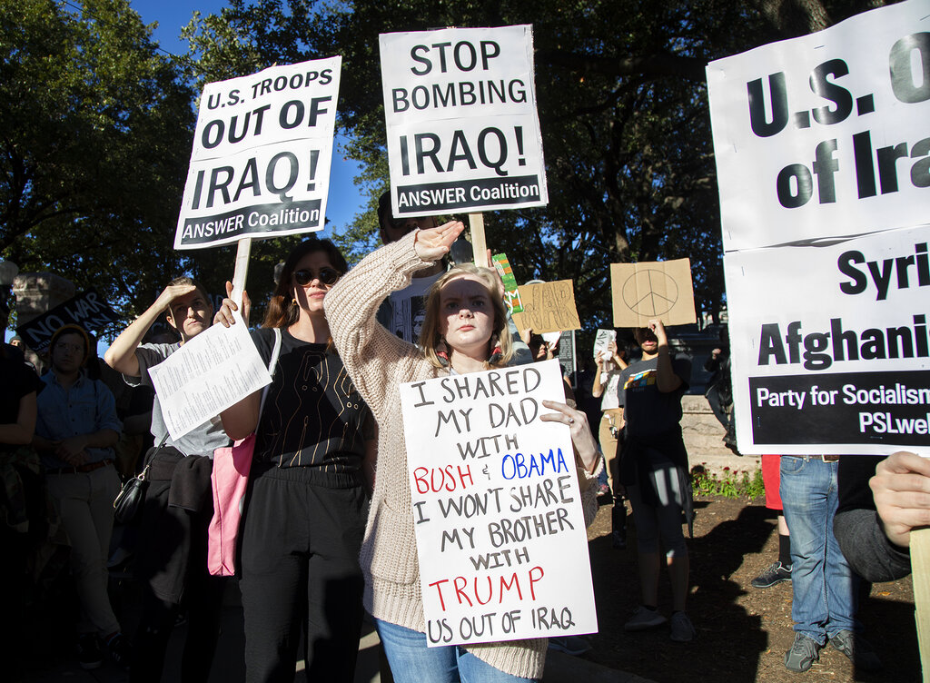 People hold signs outside the Texas state capitol in Austin, Texas on Saturday, January 4, 2020, to protest the possibility of a new war in the Middle East.
