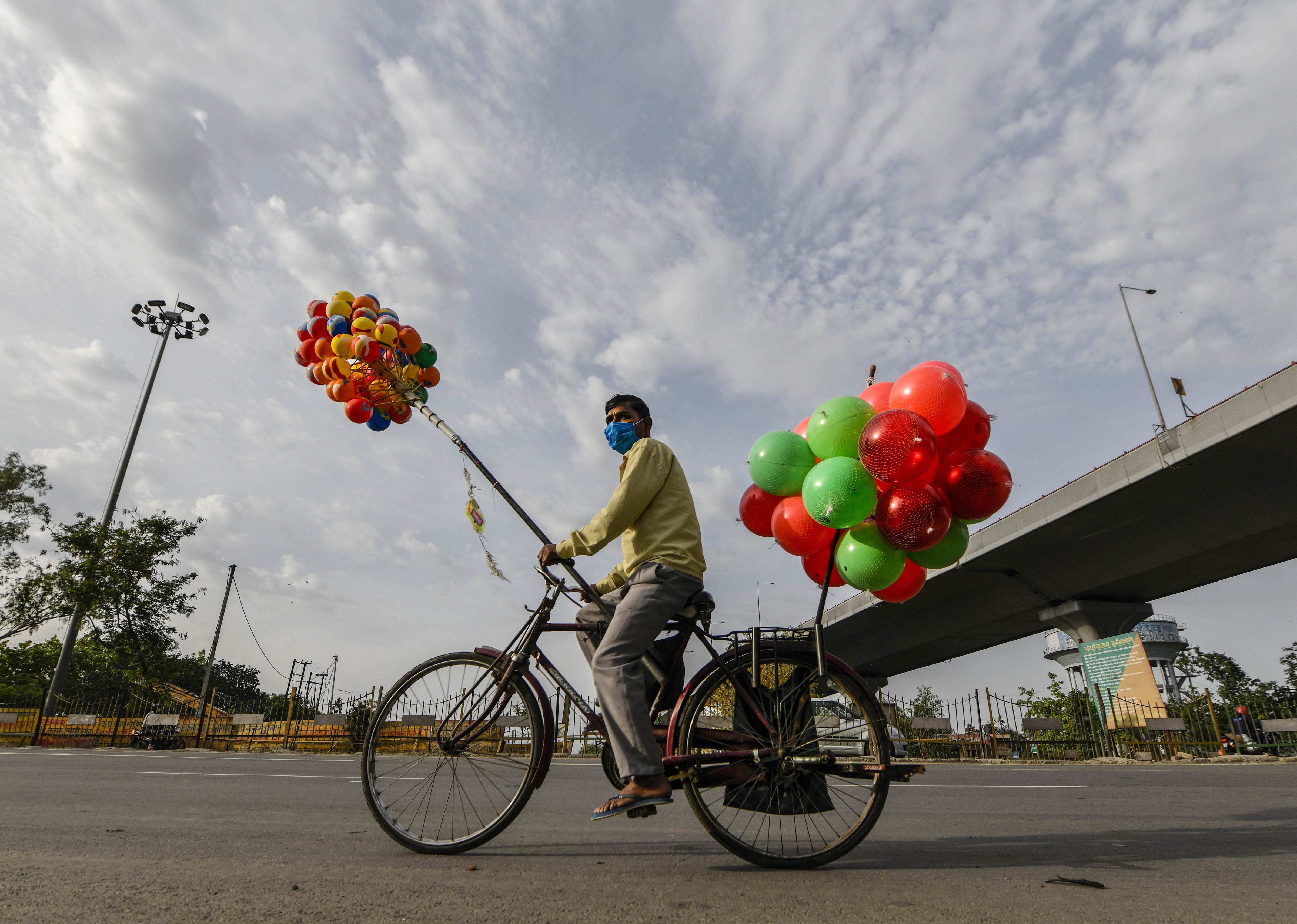 A balloon seller cycles on a road during ongoing Covid-19 lockdown in Ghaziabd, Sunday, April 19, 2020