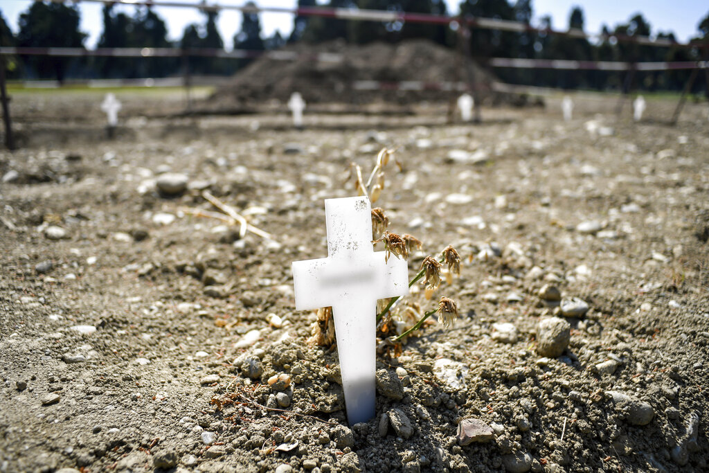 White crosses delimiting the areas for new burials are scattered at the Maggiore cemetery in Milan, Italy, Thursday, April 23, 2020.