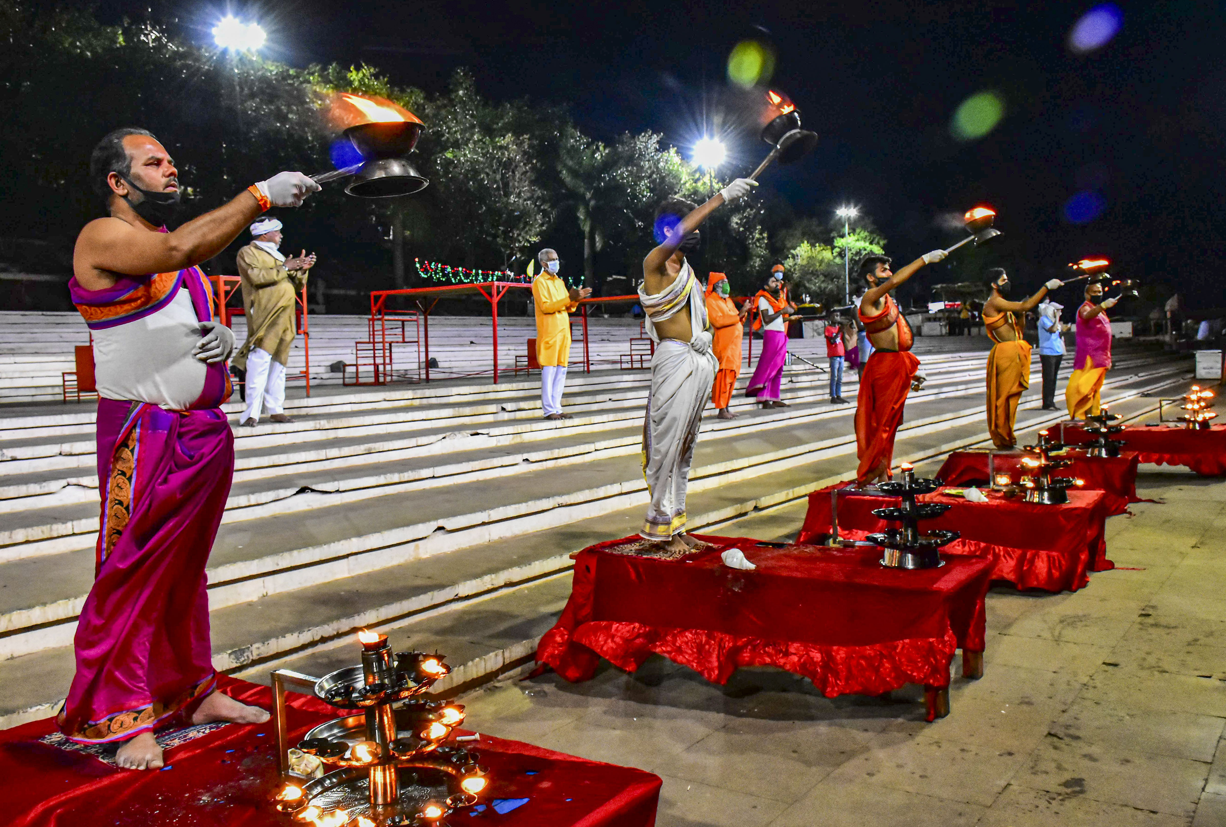 Hindu priests maintain social distance while offering Maha Aarti on the banks of River Narmada during the nationwide lockout, in wake of the coronavirus outbreak, in Jabalpur, Tuesday, March 31, 2020