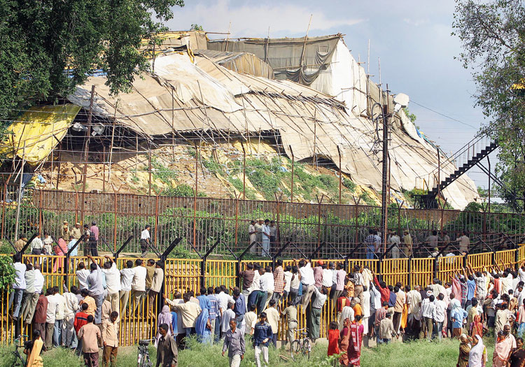 People look through the fence of the high-security complex  in Ayodhya on July 5, 2005