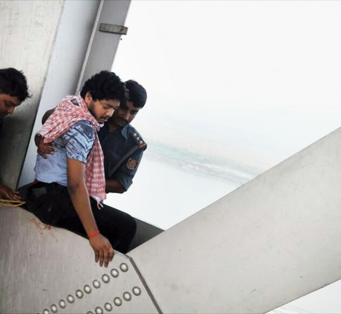 The men lift the youth into position for rescue