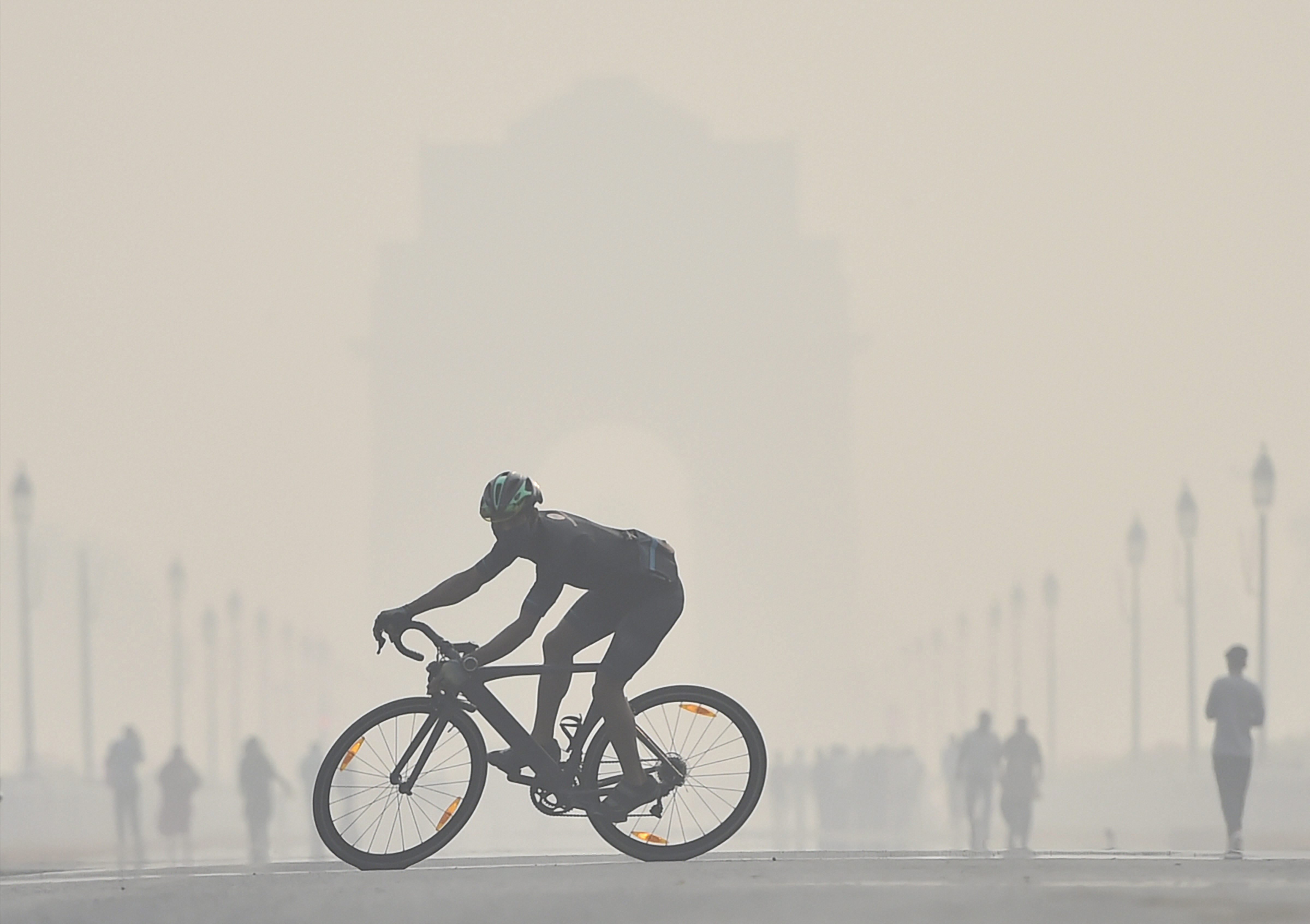 A cyclist silhouetted against a smog-covered India Gate on Thursday. The overall air quality index of Delhi has been recorded at 392, which falls in the ‘very poor’ category and is just eight points from turning severe.