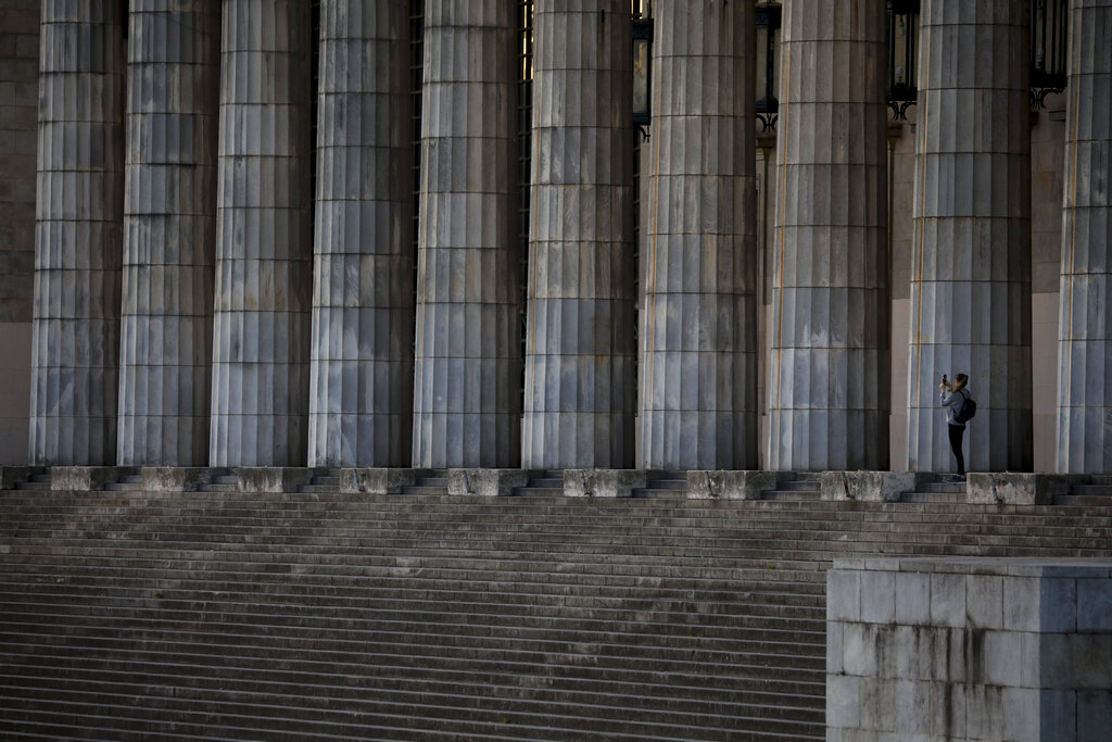 A woman takes a picture of the University of Buenos Aires Law School colonnade during a government-ordered lockdown to curb the spread of the new coronavirus, in Buenos Aires, Argentina, on Monday