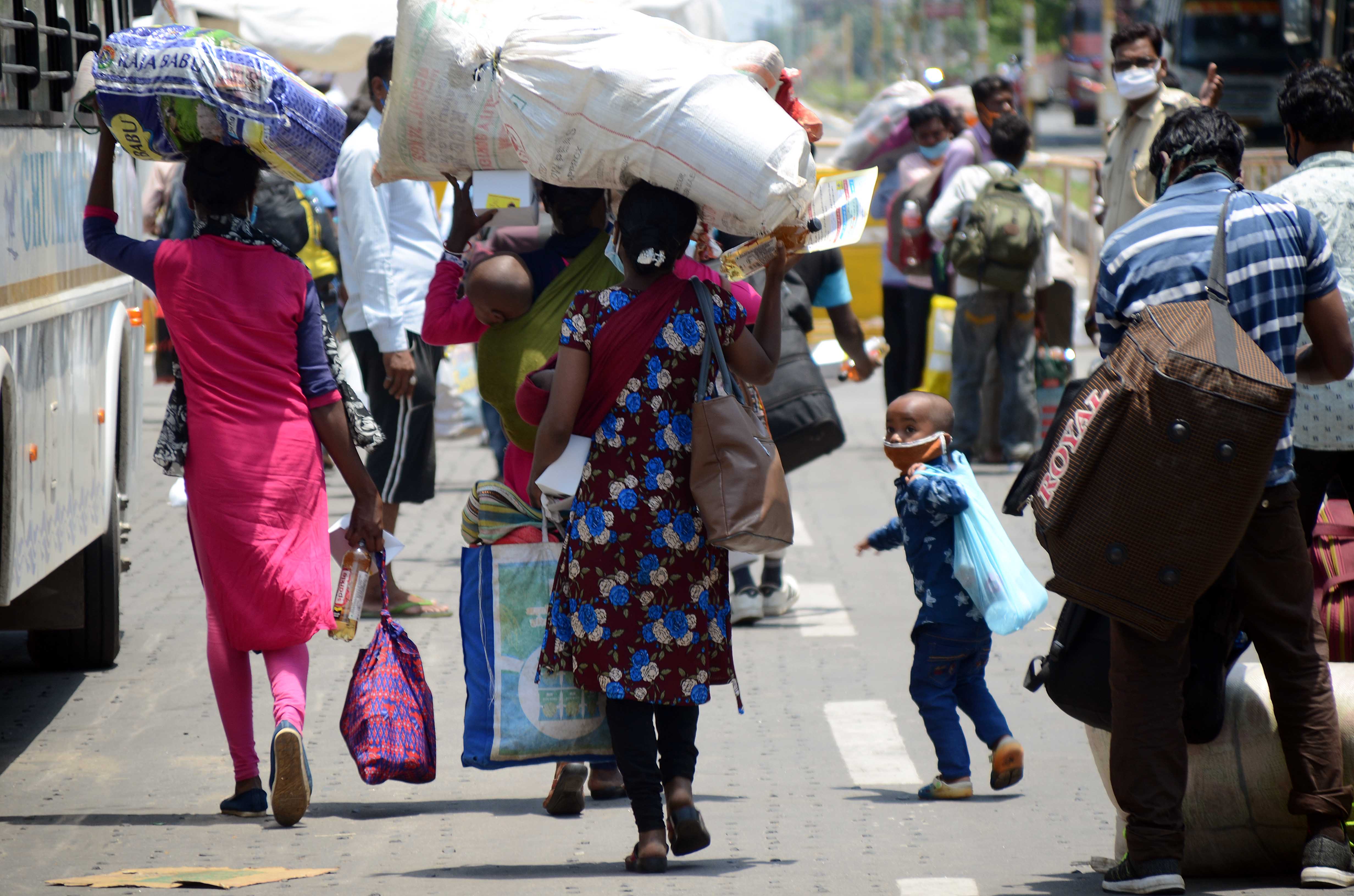 Workers make their way to board buses arranged by the local administration to take them to their homes in various districts of the state.