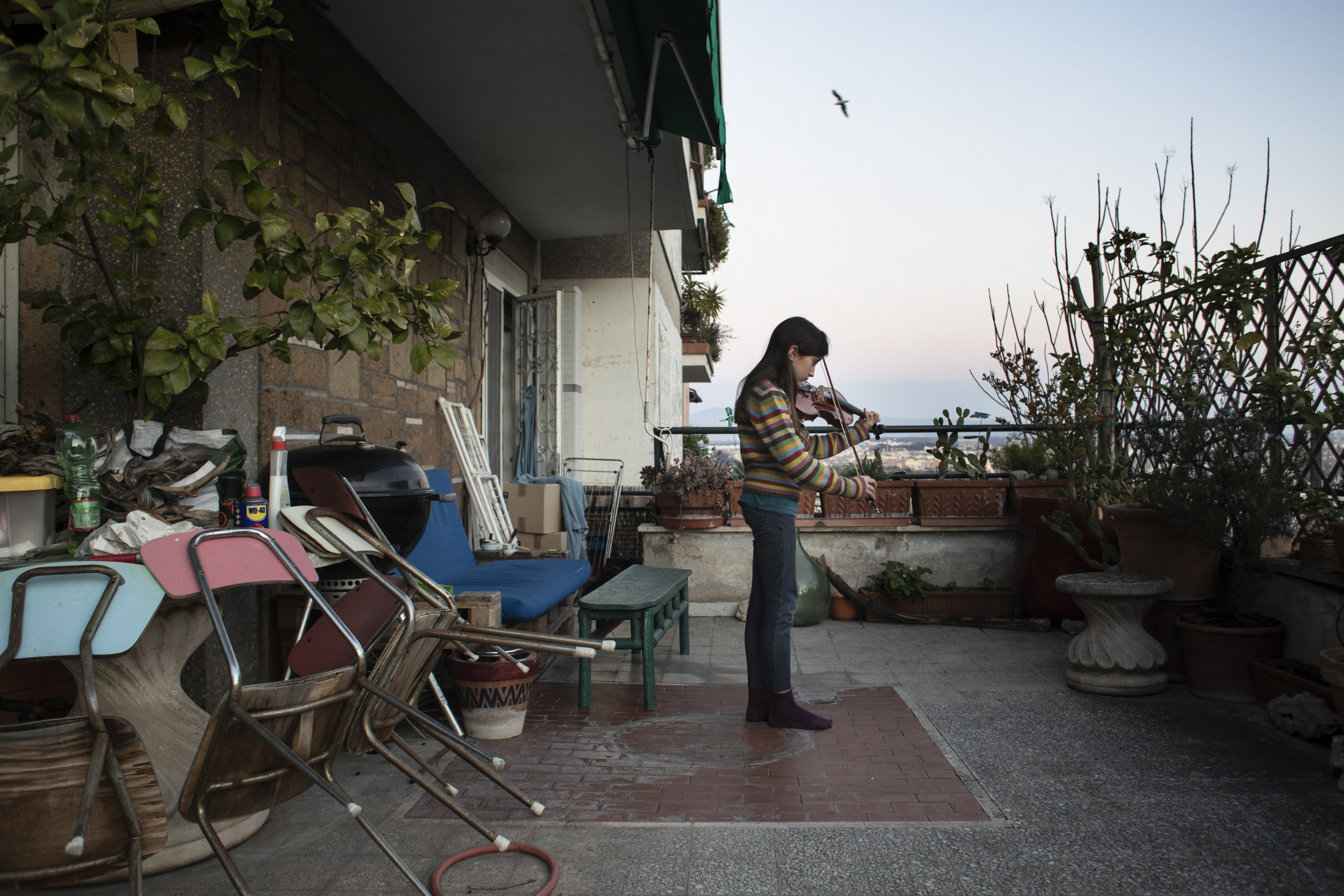 Iole Liguore, 11, plays the violin on her terrace in Rome, Sunday, March 15, 2020, in a show of solidarity during the caronavirus lockdown. She attends a school which has a special concentration for students in music.