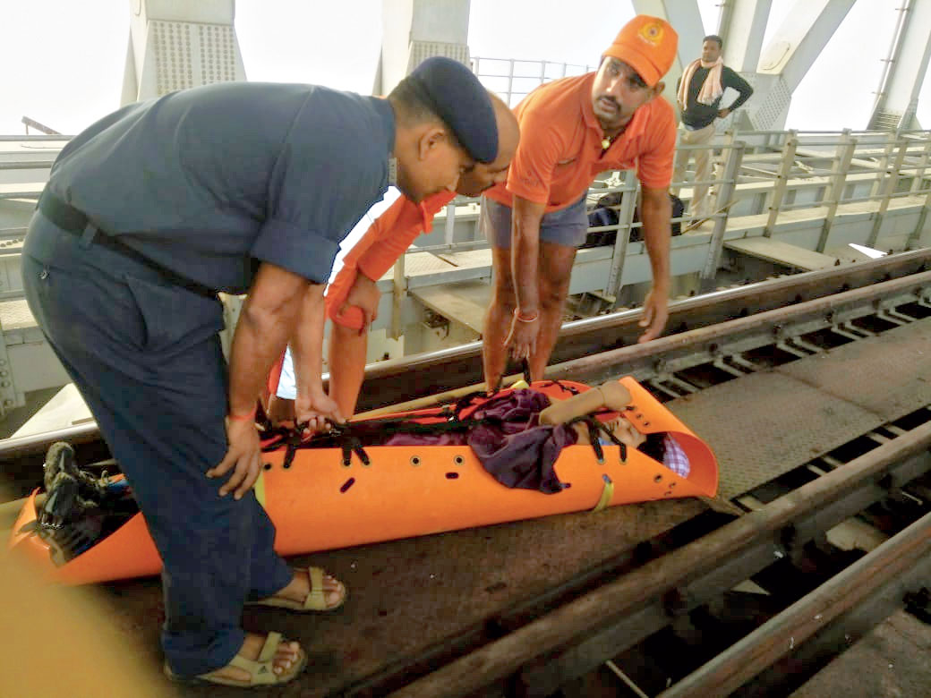 The men place the youth on the bridge after the rescue