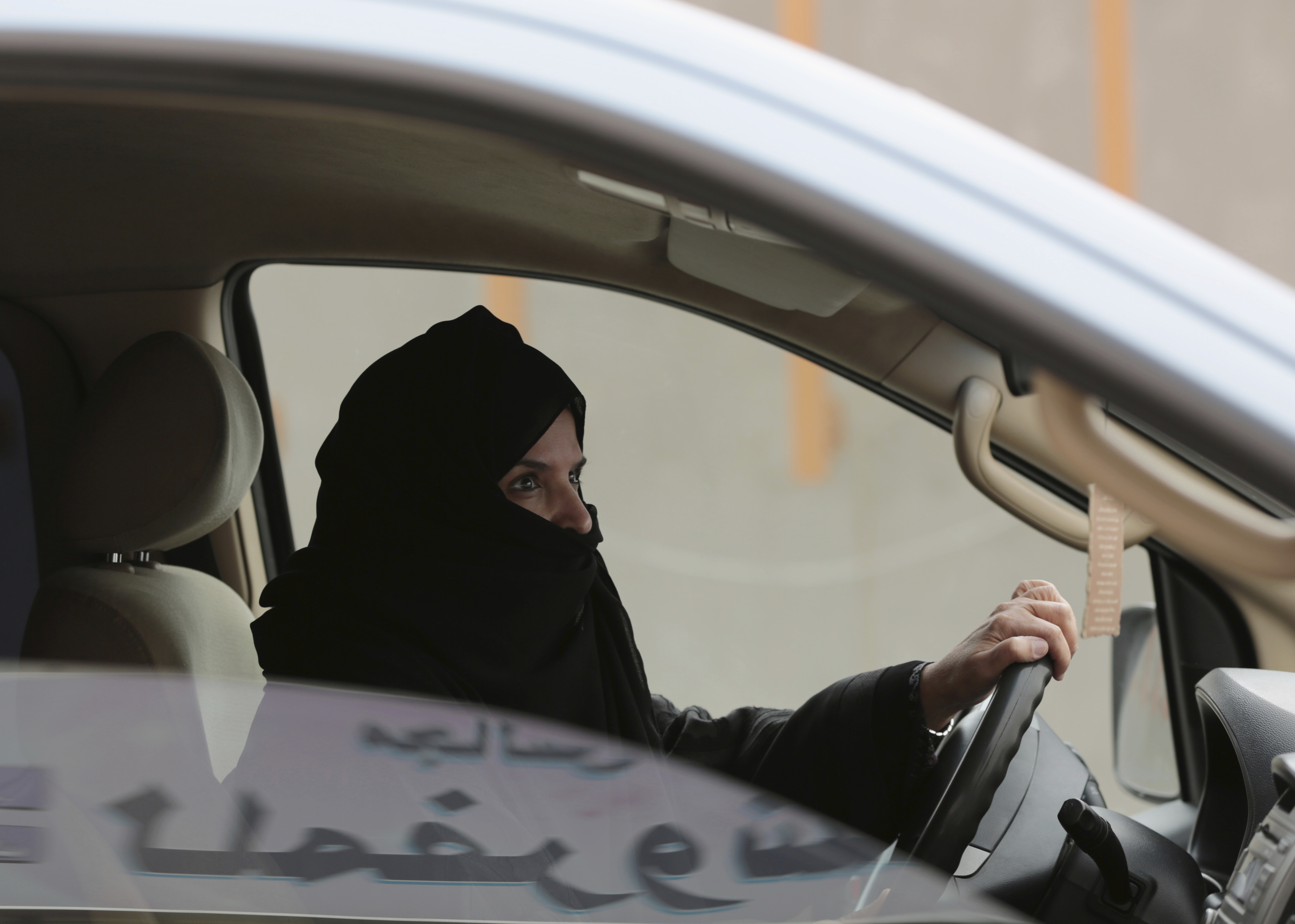 Aziza al-Yousef drives a car on a highway in Riyadh, Saudi Arabia, as part of a campaign to defy Saudi Arabia's then ban on women driving. 