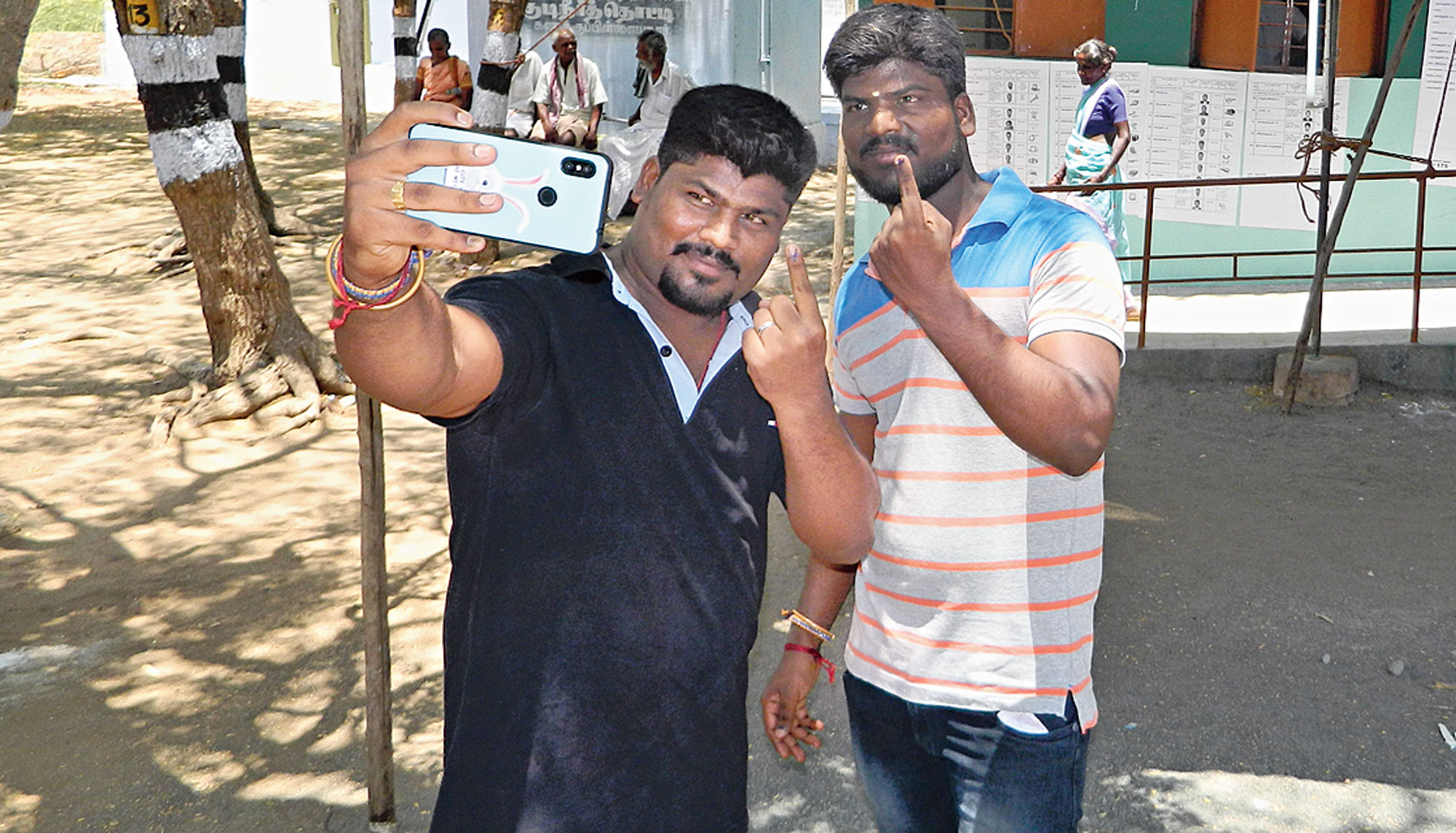 Youths click selfies after voting at Kanakapillaipudur village in Karur on Thursday.