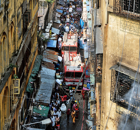 Fire tenders in Calcutta struggle to pass through the congested Amartalla Lane, almost gobbled up by encroachers, to reach Bagree Market (right) from the rear on Monday. 