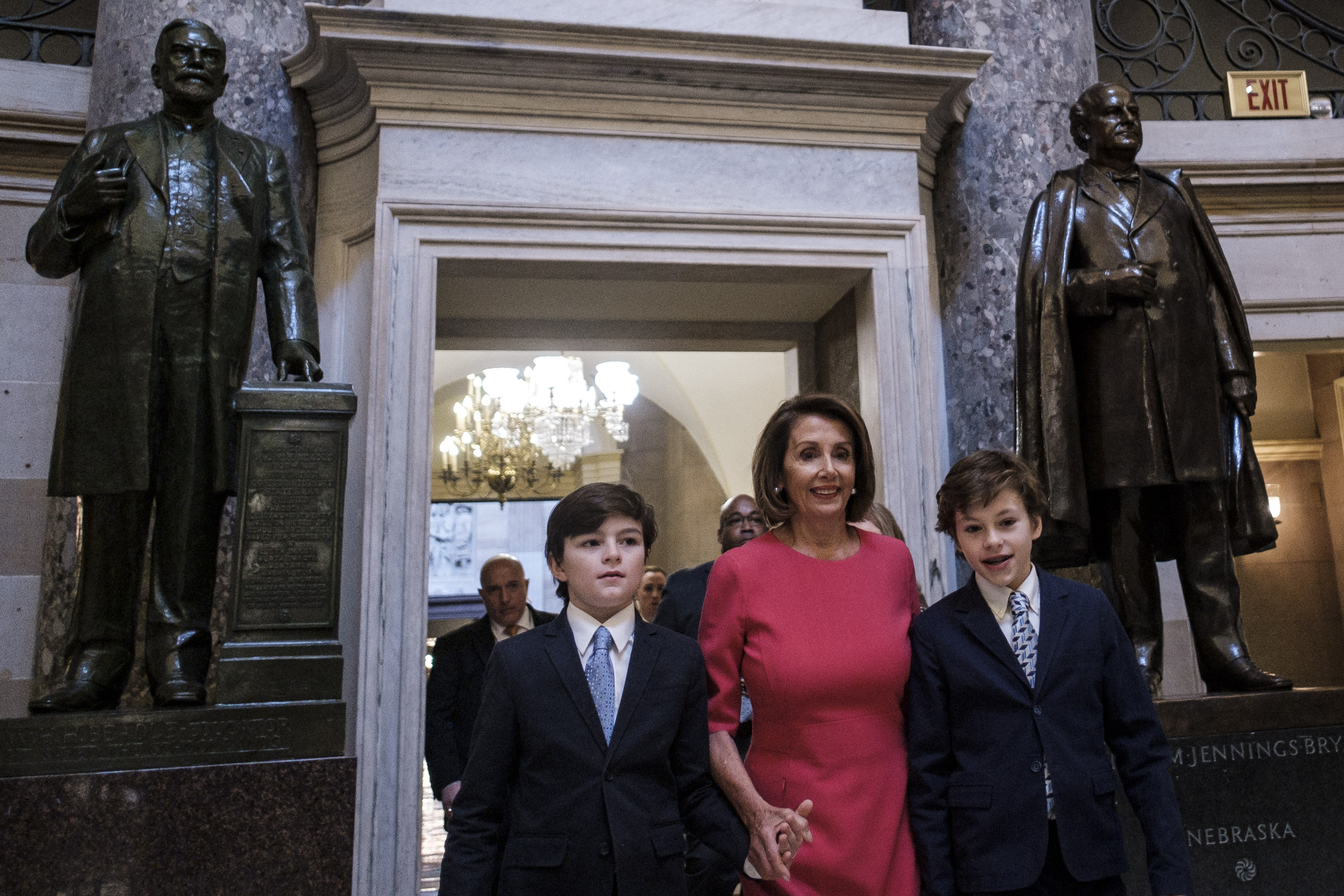 Nancy Pelosi is flanked by her grandsons Thomas (left) and Paul Vos as she walks to the House Chamber of the Capitol on Thursday.