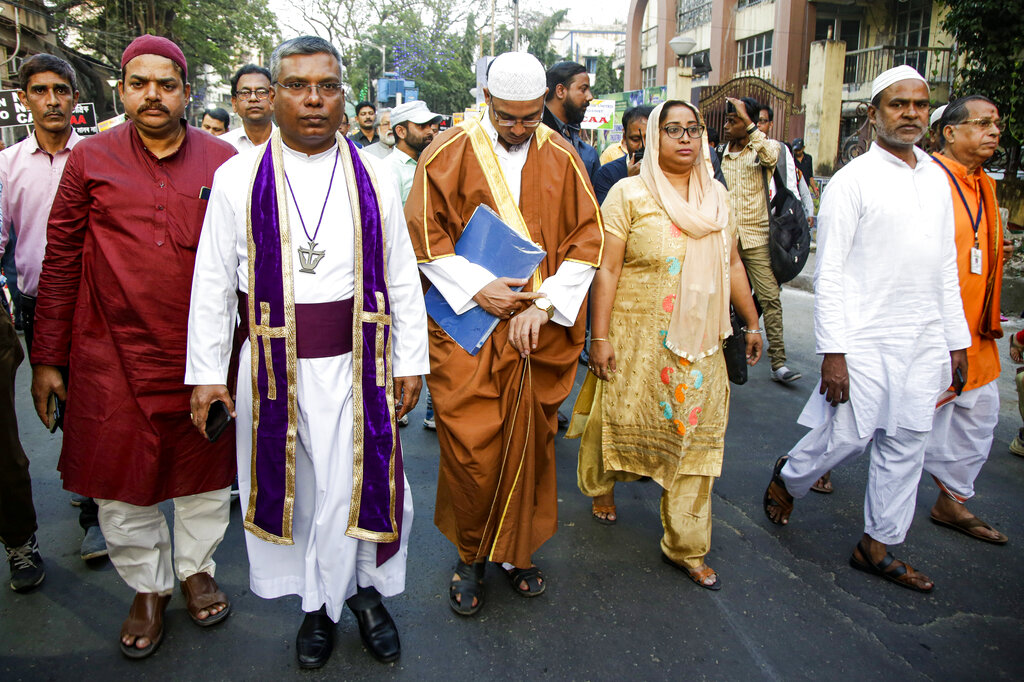 Priests of different communities participate in a procession during a mass marriage ceremony for more than eighty couples of various religions in Kolkata, on Friday