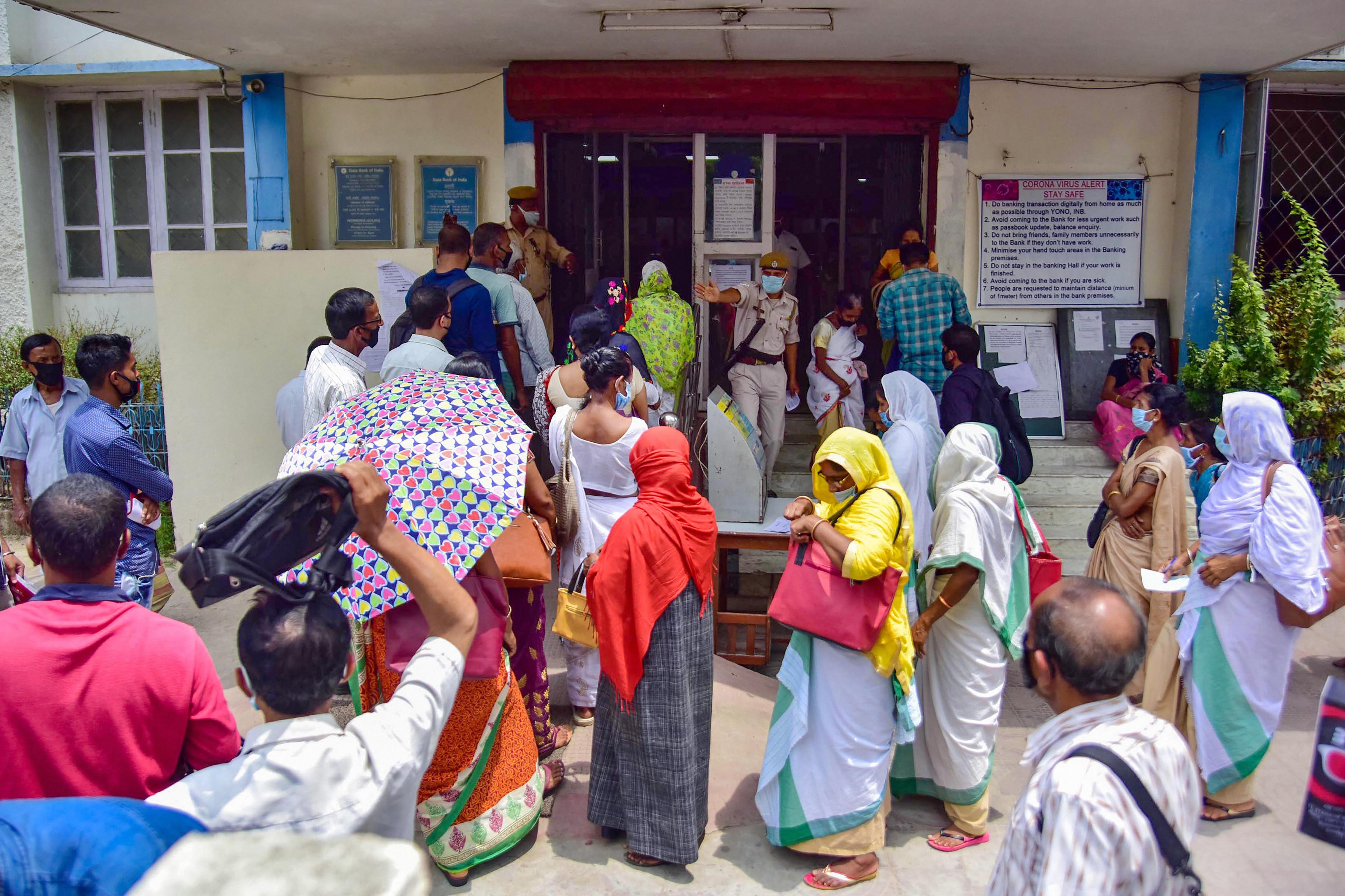 People wait outside a bank during the ongoing Covid-19 lockdown in Nagaon, Assam, Monday, May 4, 2020.