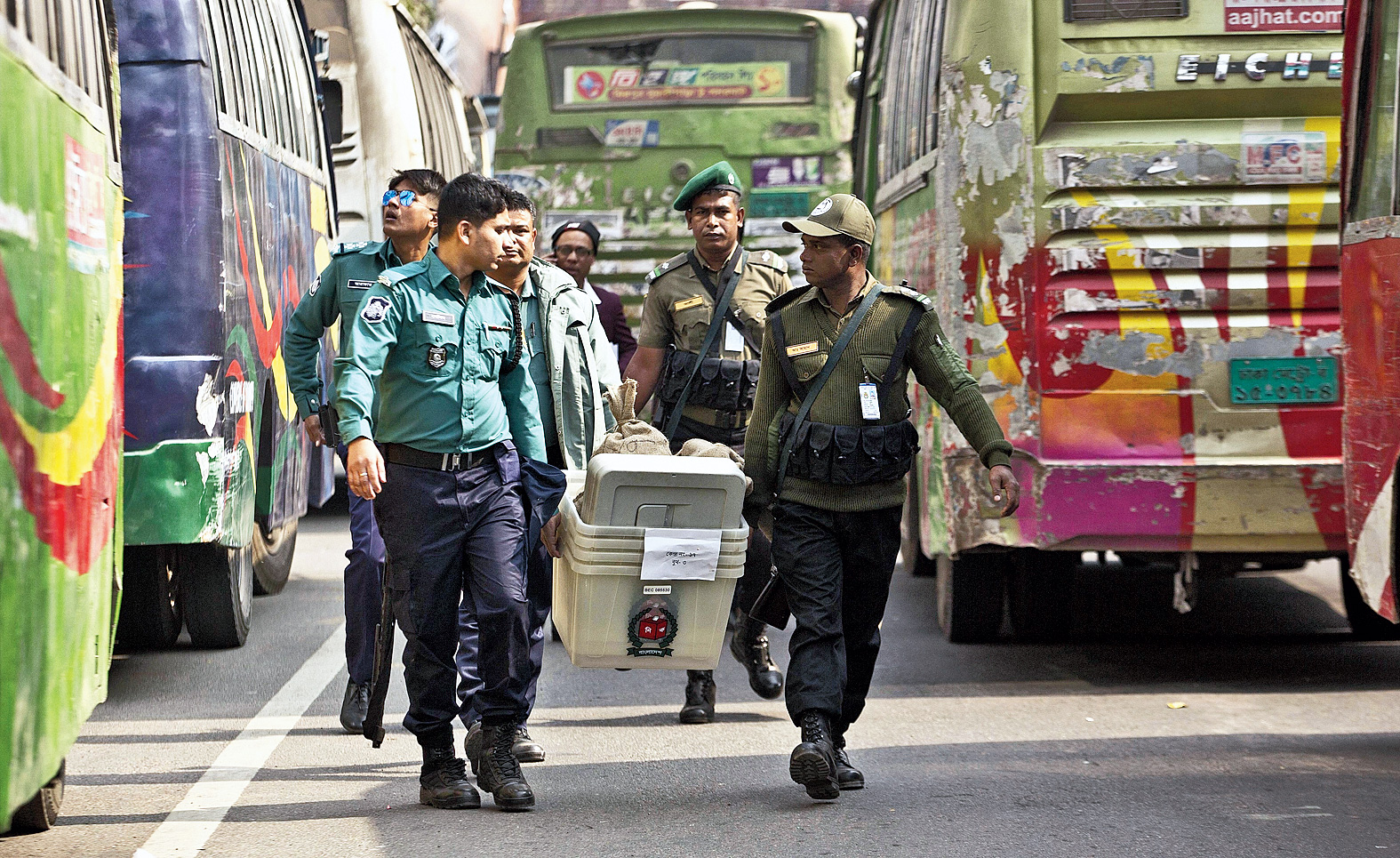 Security personnel carry voting material in Dhaka on Saturday.
