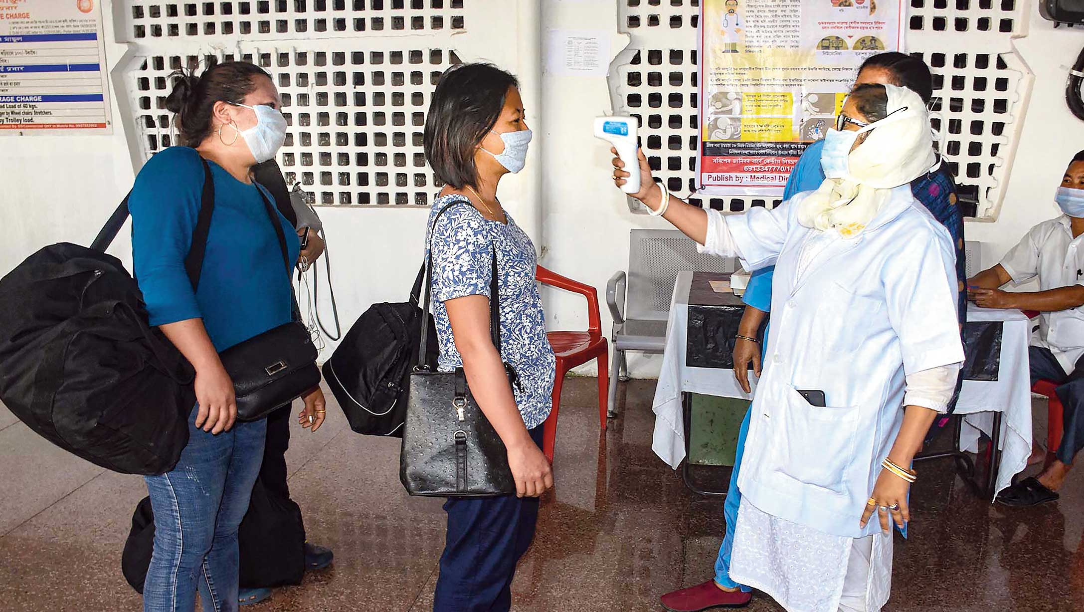 A health worker conducts thermal screening of a passenger at Guwahati railway station on Monday. 