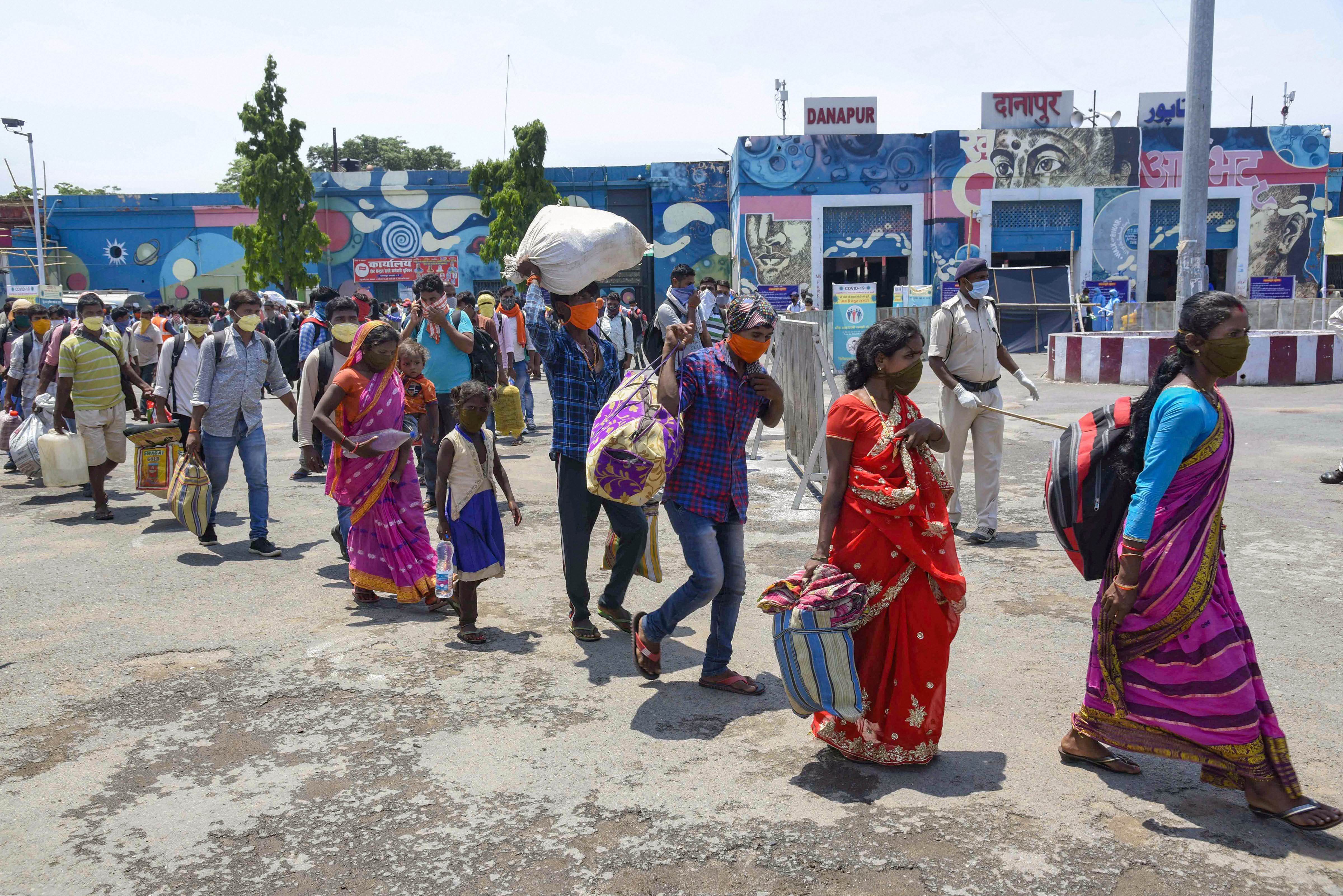 Migrants arriving by a special train, wait in a queue to board buses to reach their homes, during the nationwide lockdown in the wake of coronavirus pandemic, in Patna, Monday, May 11, 2020
