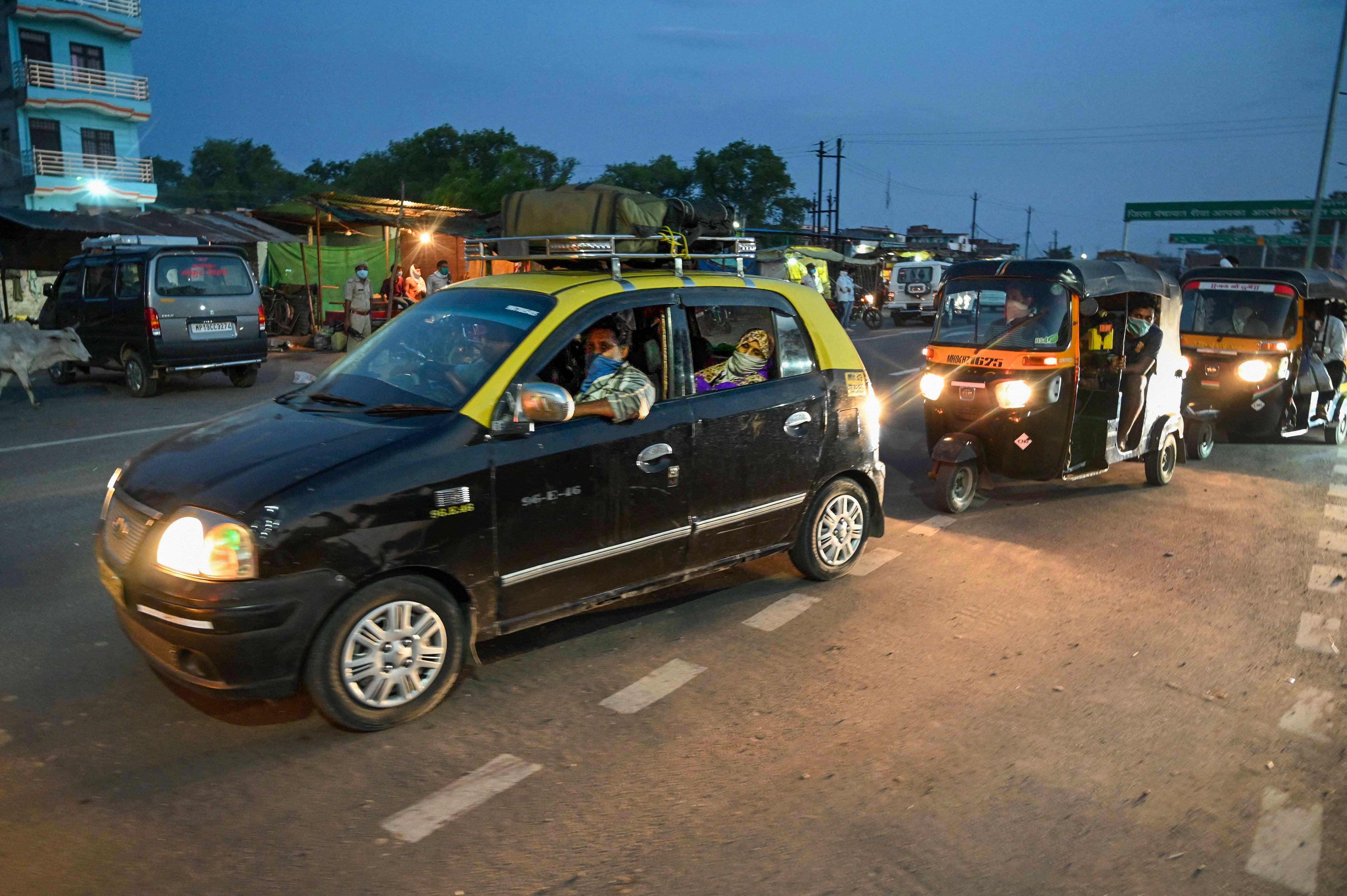 Migrants travelling via taxis from Mumbai ride towards their native places during the ongoing nationwide Covid-19 lockdown, at Uttar Pradesh- Madhya Pradesh Border, Chakghat in Prayagraj, Tuesday, May 12, 2020