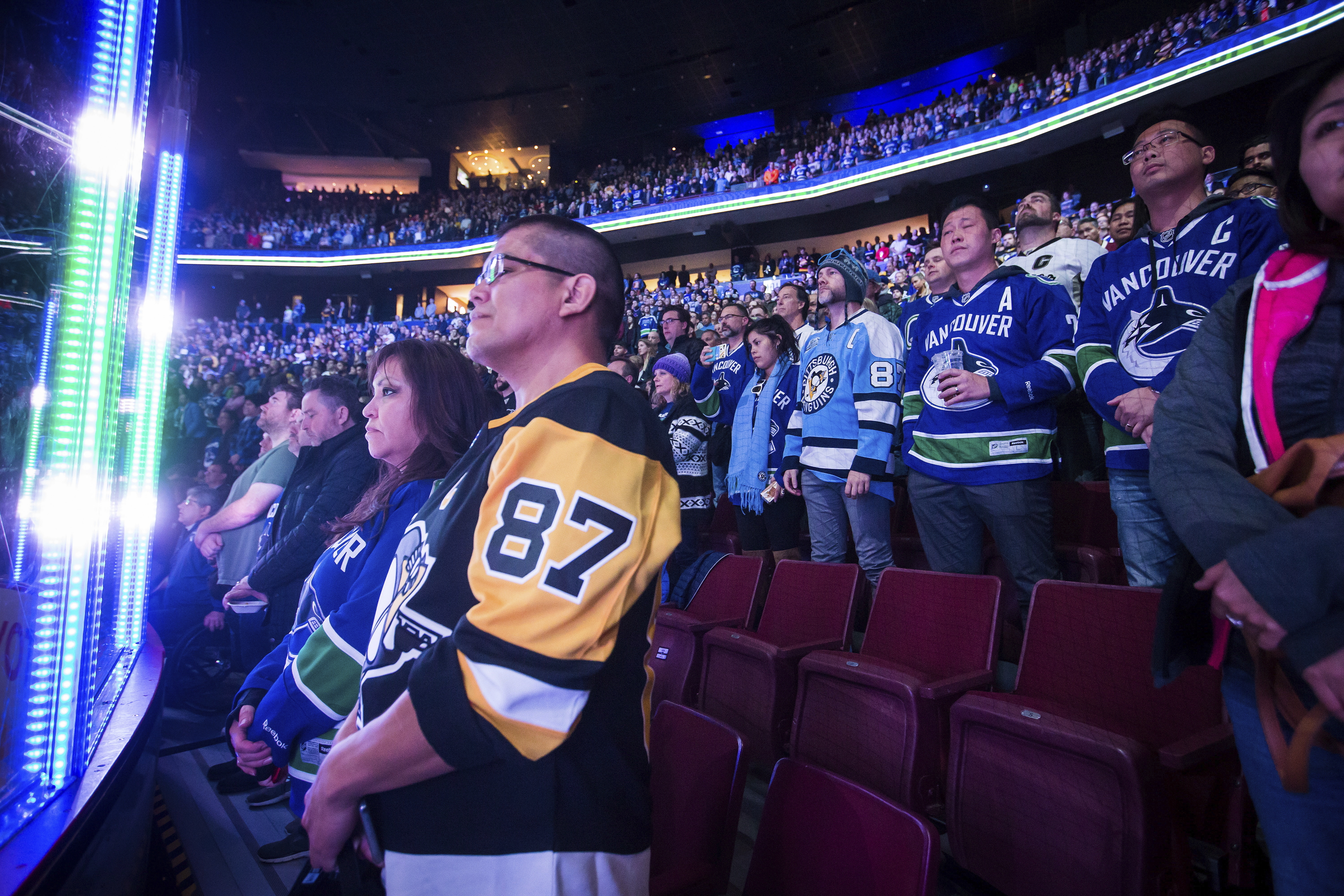 Spectators stand during a moment of silence for the victims of a shooting at a Pittsburgh synagogue before the Vancouver Canucks and the Pittsburgh Penguins play an NHL hockey game in Vancouver, British Columbia, on October 27.