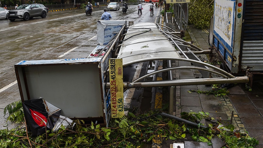  People walk past a damaged bus stand that collapsed during heavy rain at Churchgate on Thursday