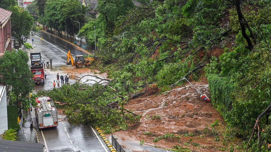 Municipal workers clear debris from Pedder road, after a landslide due to heavy rainfall on Thursday