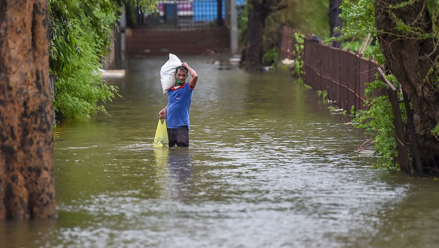 A man wades through a waterlogged area after heavy rainfall, at Grant Road in Mumbai on Thursday