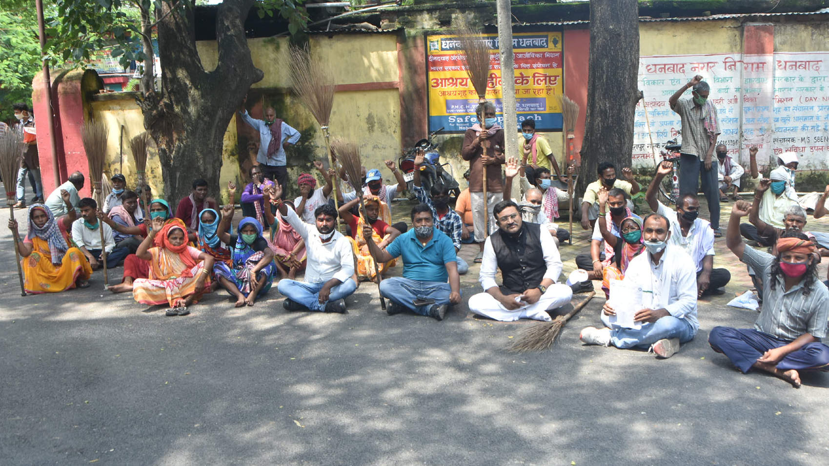 Sanitation workers of Dhanbad Municipal Corporation staging dharna at the DMC office on Luby Circular Road in Dhanbad on Friday.