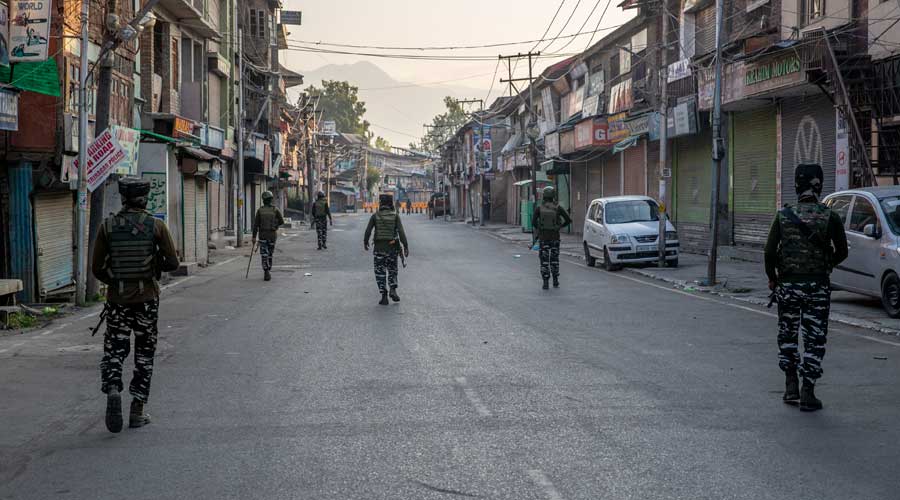 Paramilitary soldiers patrol a deserted street in Srinagar on Wednesday, August 5