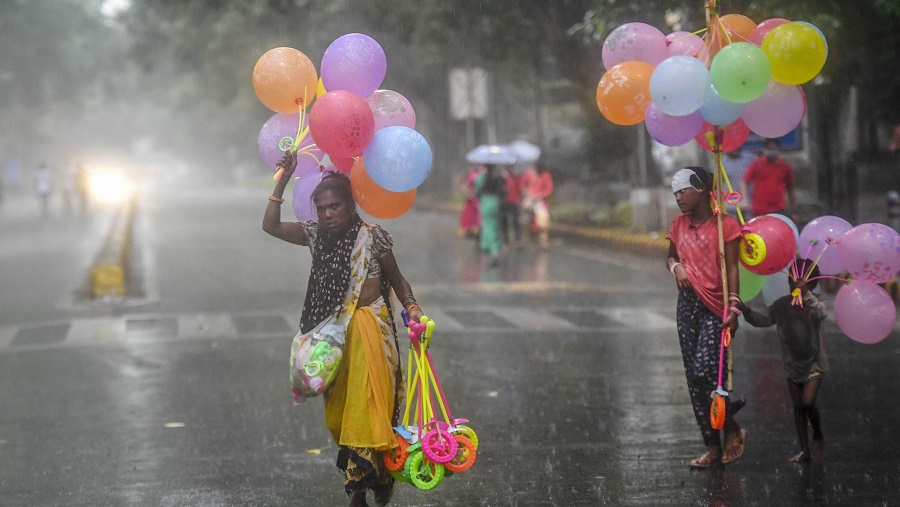 Balloon sellers walk in the rain outside Birla Mandir, in New Delhi on Wednesday.