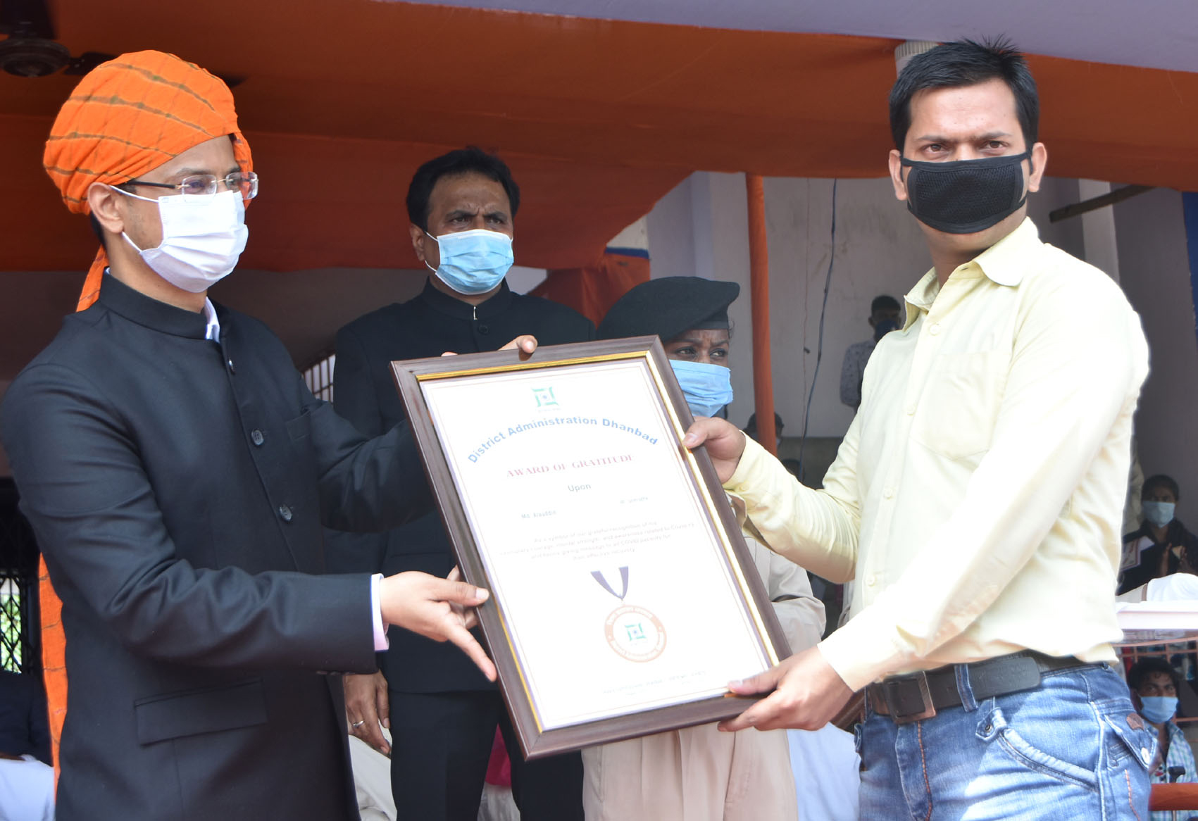 Dhanbad DC Uma Shankar Singh felicitates Md Allauddin who beat Covid-19, and was the first person of district to recover