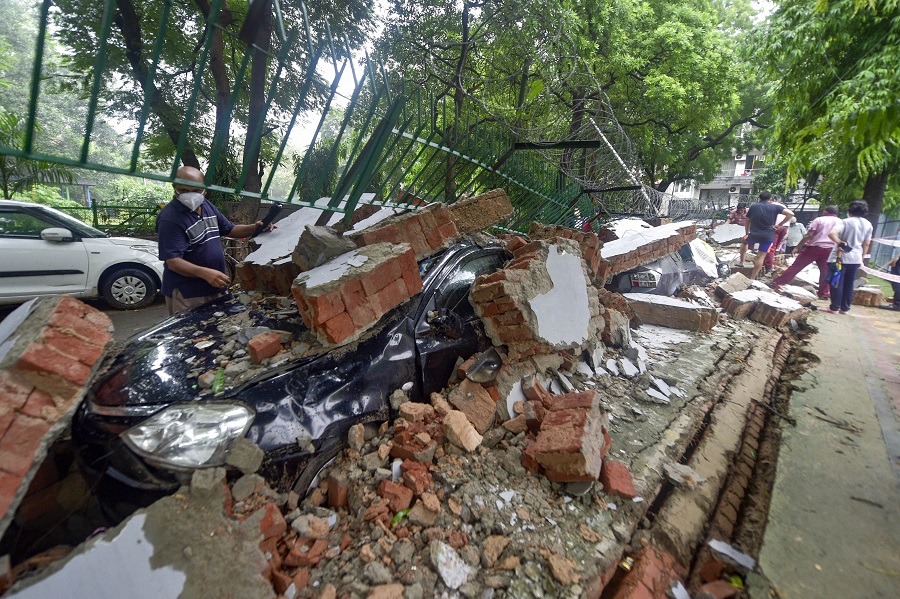A vehicle buried under the debris after wall of a public school collapsed due to heavy rains, at Saket in New Delhi on Wednesday