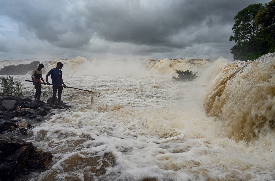 Fishermen cast their net for fishing in the swollen Narmada river following heavy rain, in Jabalpur on Wednesday.