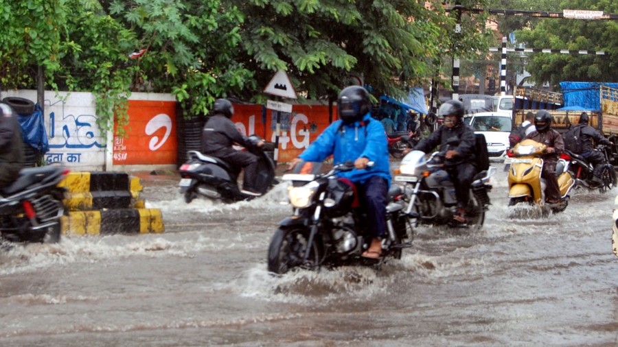 People drive their two-wheelers on the flooded Jugsalai-Station Road on Friday. 