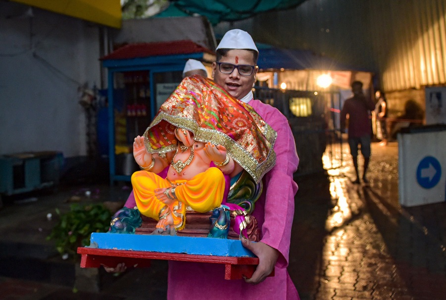 A devotee carries a Ganesh idol on the eve of Ganpati festival, at Dadar in Mumbai on Friday.