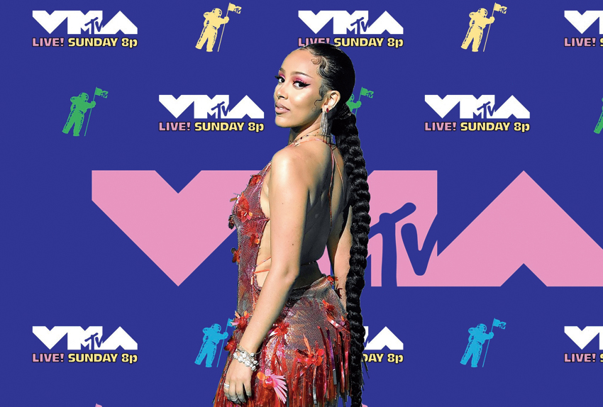 3. Doja Cat kept the hotness metre soaring high in a backless and plunging neckline metallic red dress that had floral detailing and fringes. Big hoops, red eyedo and a long braided hairstyle summed her red-carpet look.