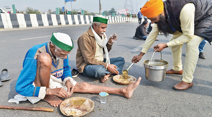 Farmers eat at the Delhi-Uttar Pradesh border on Friday.