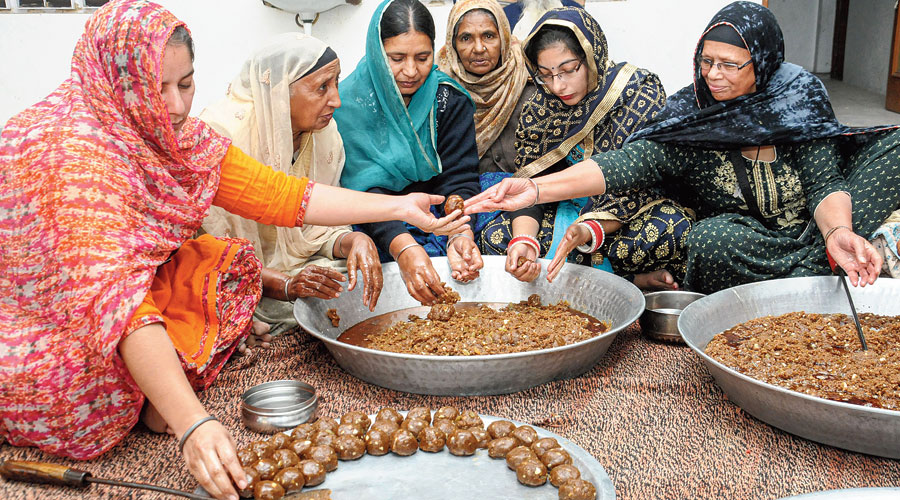 Women prepare pinni, a sweet, for farmers in Jalandhar.