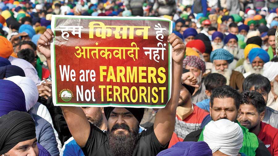 The protesting farmers hold up a poster at the Singhu border.  