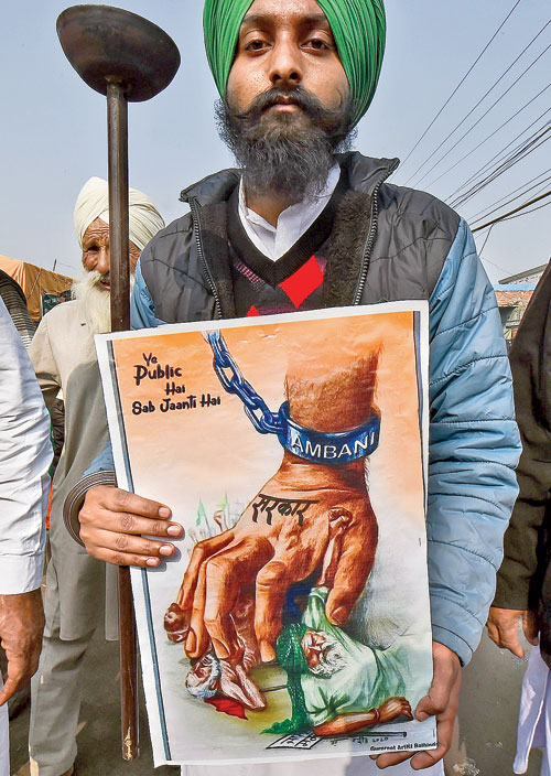 A farmer holds a poster at the Singhu border.