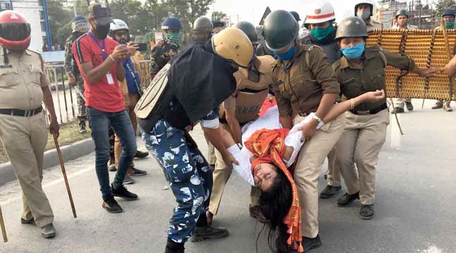 Police remove a BJP supporter in Siliguri following violence on Monday.