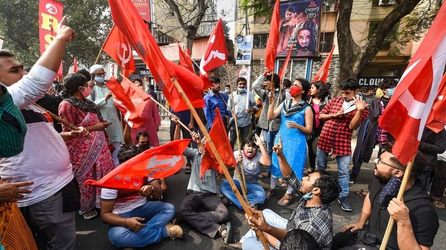Trade union activists block a road in Kolkata to support Tuesday's Bharat Bandh.