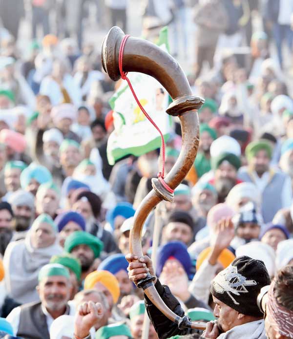 A farmer plays a bugle during the protest at the Ghazipur border on Thursday. 