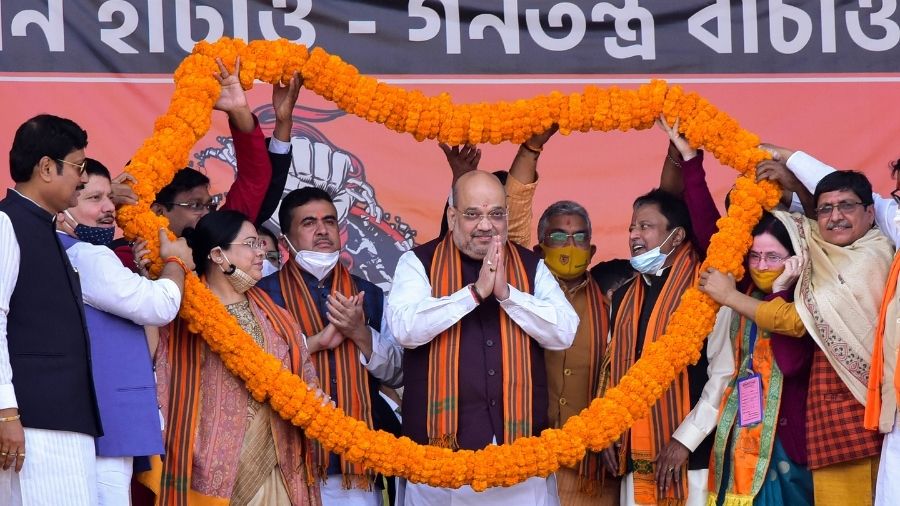 BJP leaders and workers present Union Home Minister Amit Shah with a huge garland during a rally at Midnapore on Saturday.