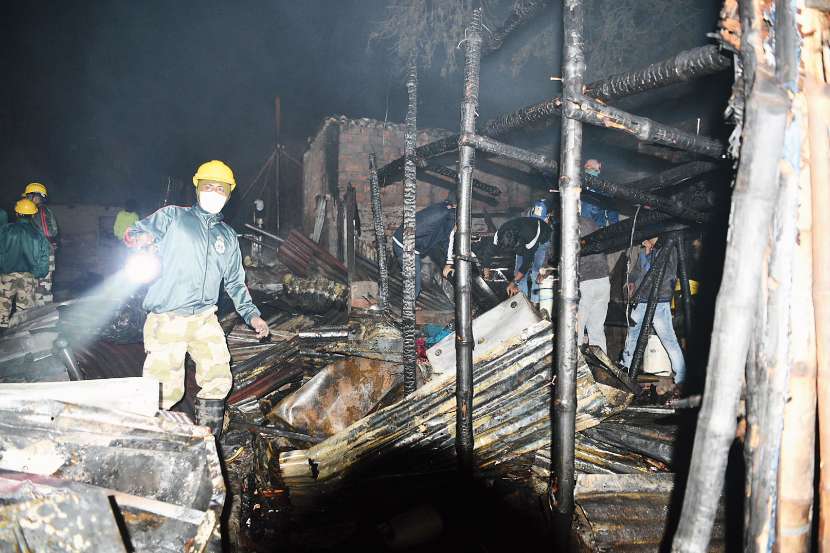 Firefighters inspect damaged homes.