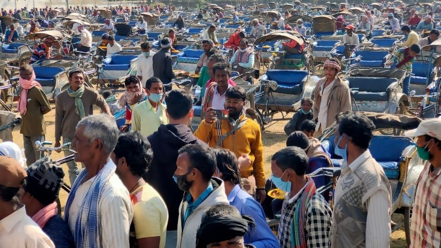 Rickshaw pullers make beelines to collect their food and blankets at the Loyola Ground in Ranchi, on Friday.