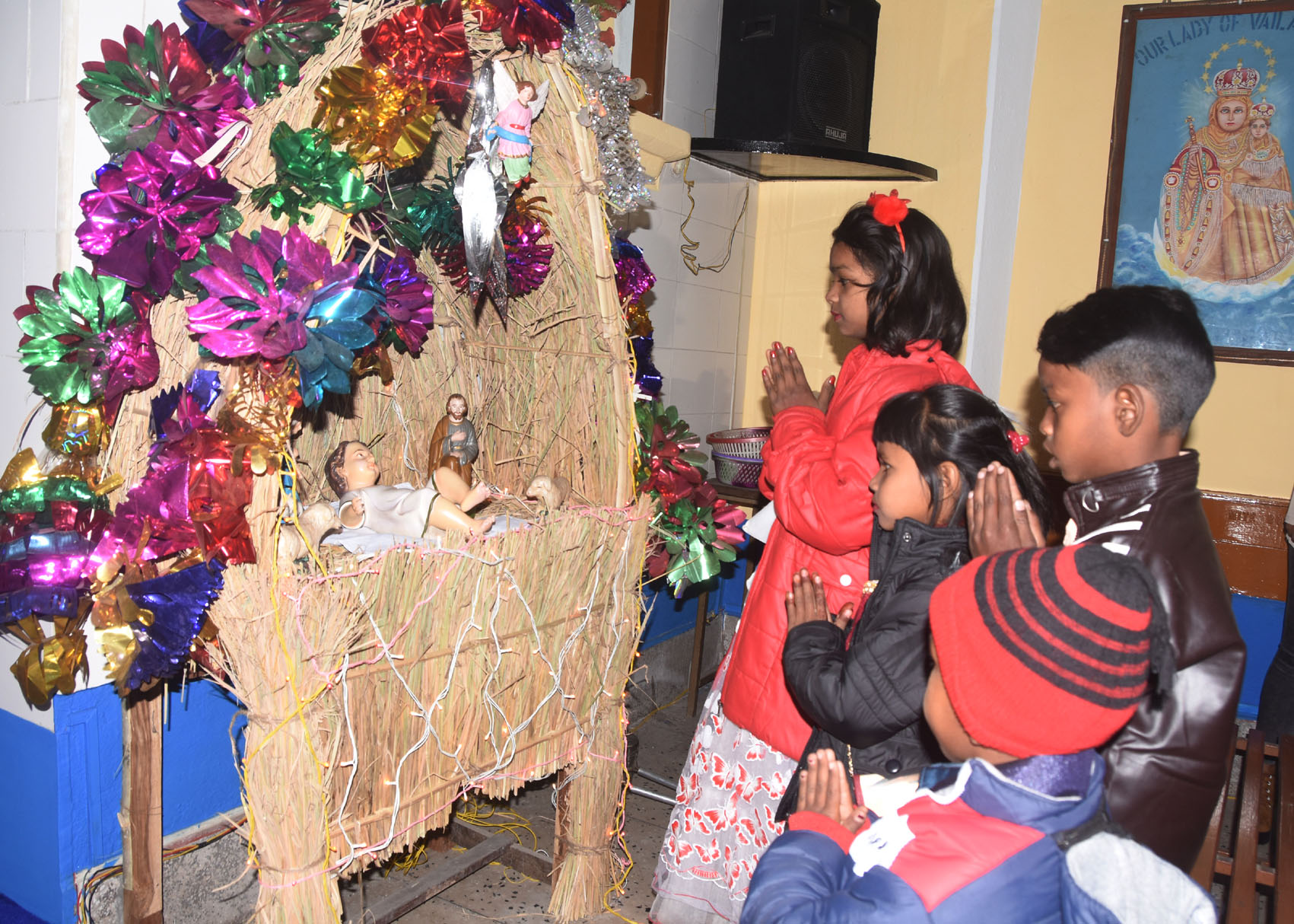Children offer prayers to baby Jesus during the morning mass at St. Anthony's Church in Dhanbad on Friday.
